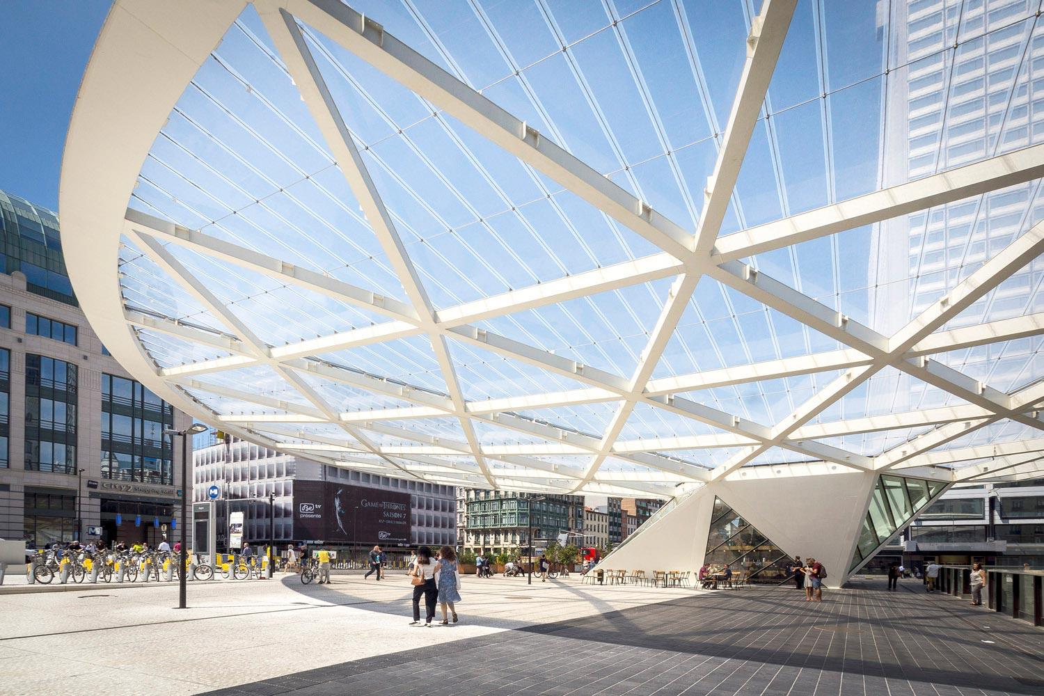 Pedestrians moving under the architectural structure of Place Rogier